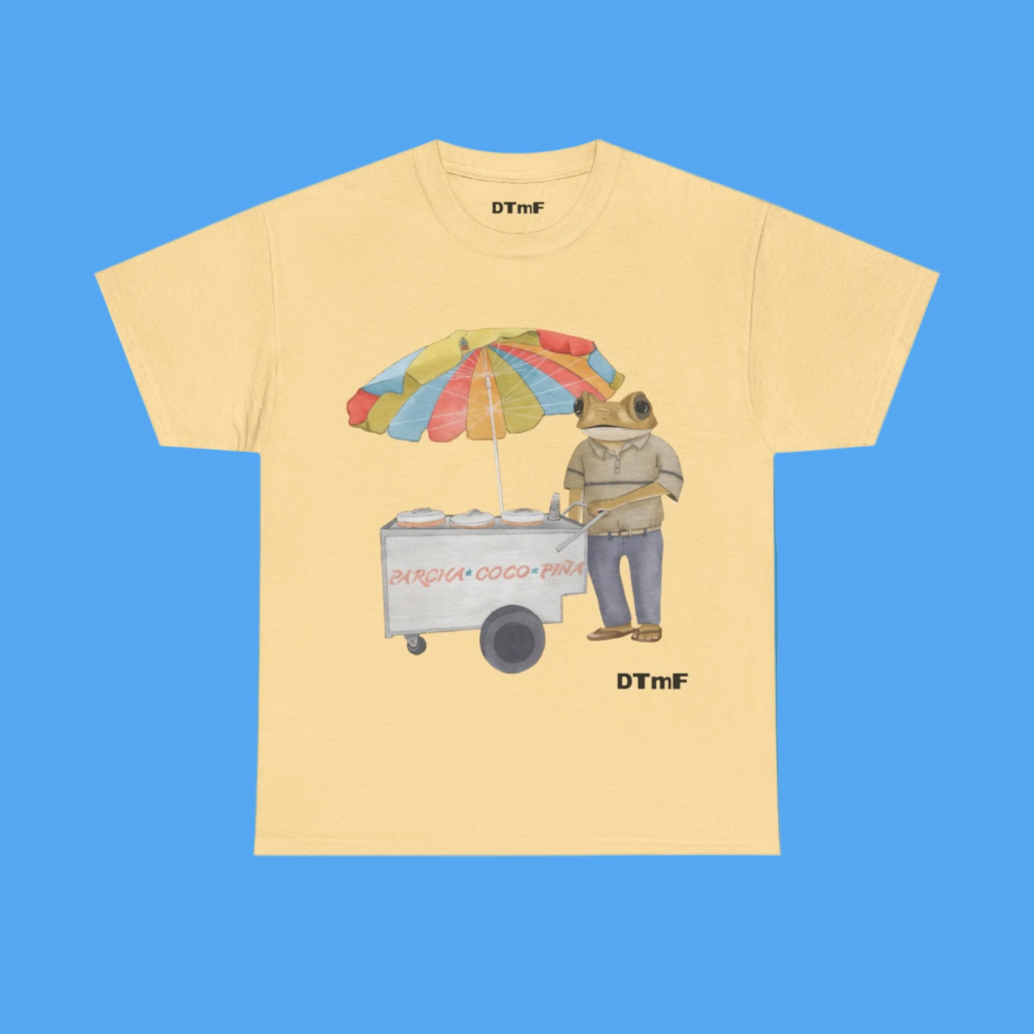 Beige t-shirt with a graphic of a bear with an ice cream cart and umbrella on a blue background